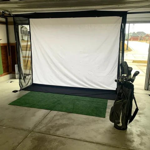View of a g-trak retractable golf enclosure with golf clubs in a garage setting