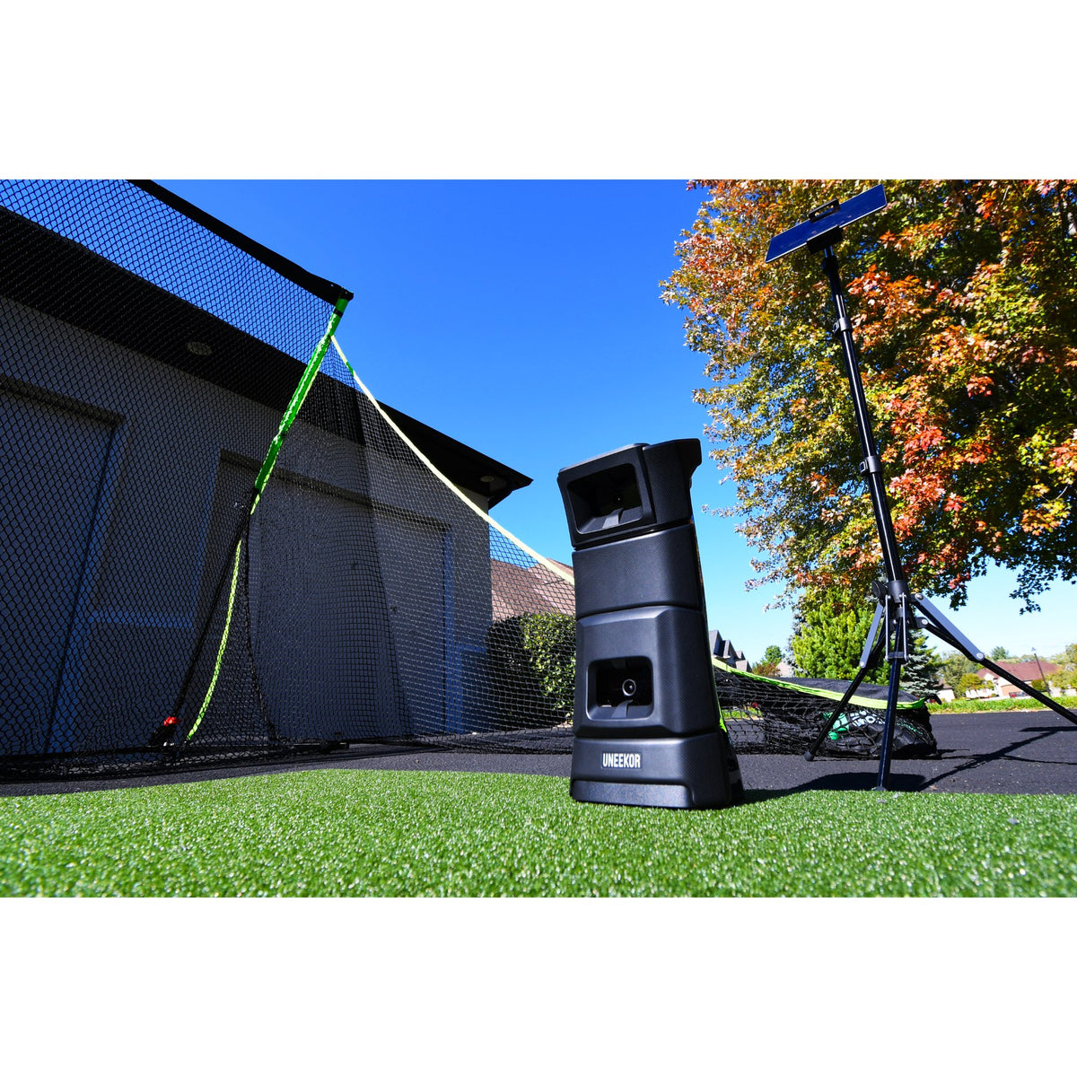 View of a Uneekor Eye Mini launch monitor placed on turf outdoors